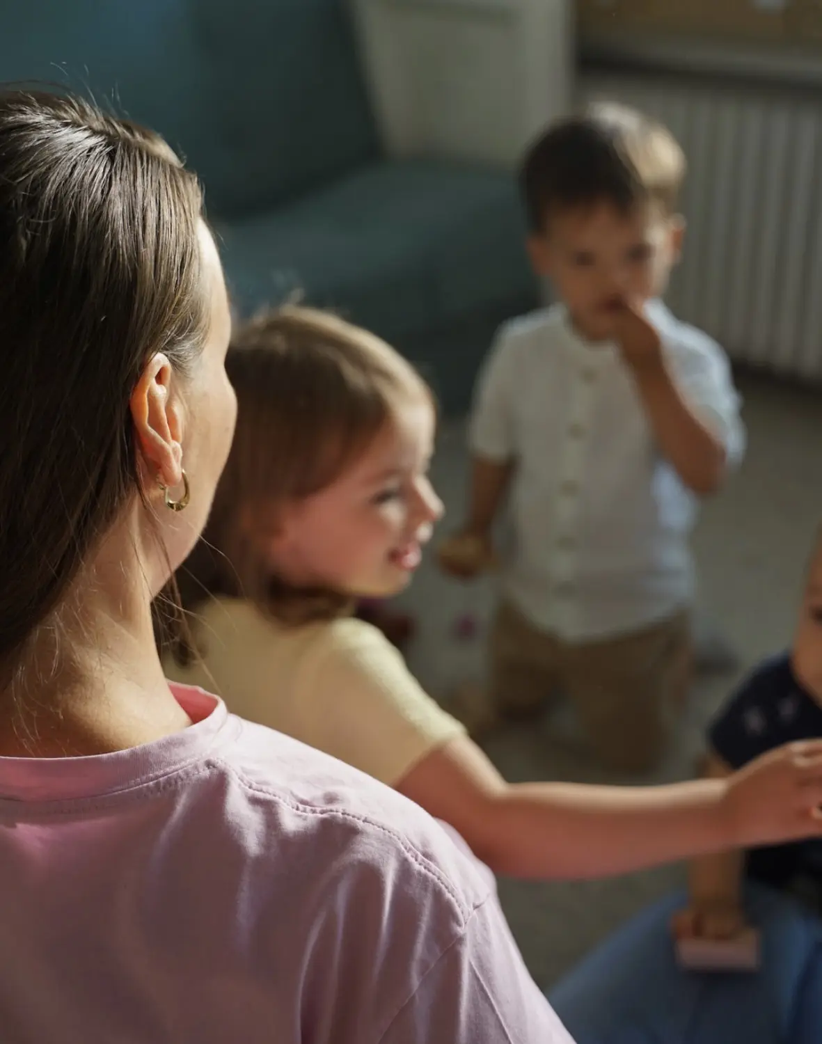Kind mit Mutter spielt im Garten von Tagesmutter